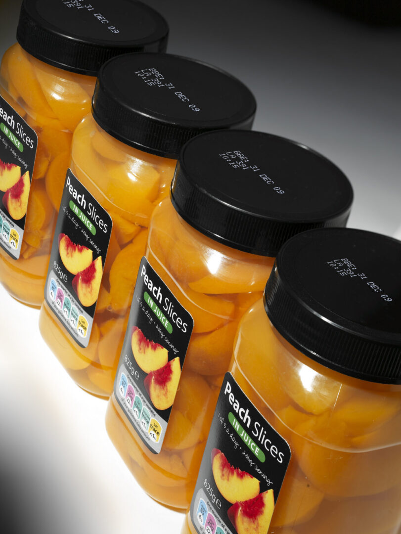 Four jars of peach slices in juice.