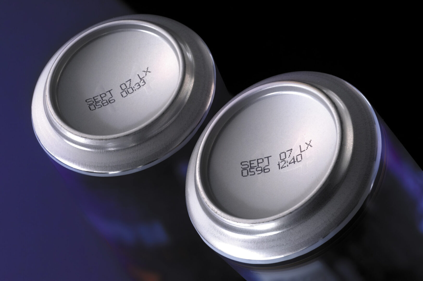 Two aluminum cans with printed dates.