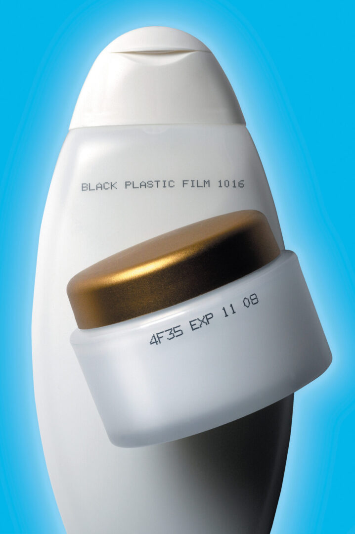 Two white plastic bottles with printed codes.