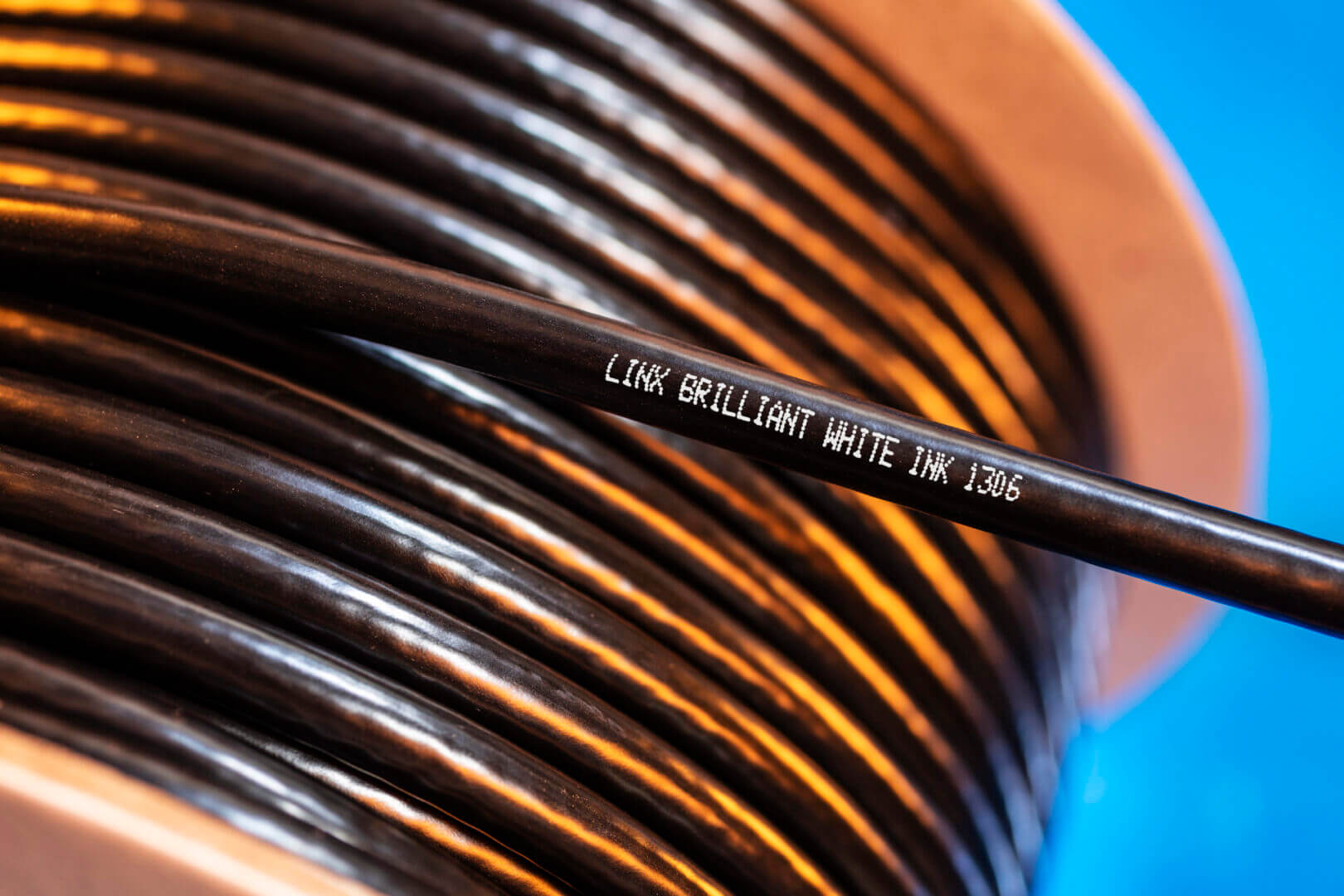 Black cable spool with white ink text.