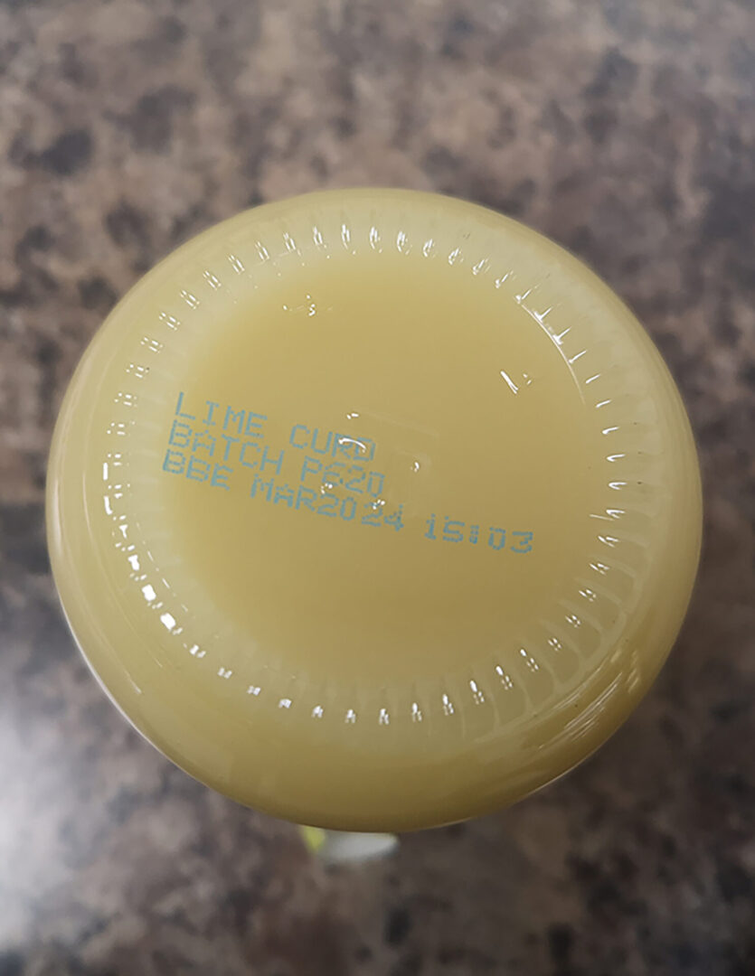 Bottom of a lime curd jar with a date.